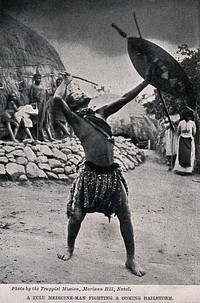 A Zulu medicine man or shaman performing a ritual to fend off a hailstorm, South Africa. Halftone after Trappist Mission, Natal.