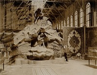 The 1904 World's Fair, St. Louis, Missouri: the Belgian pavilion: a sculpture showing a man with a gun hiding in a cave, tracked by a man with a dog. Photograph, 1904.