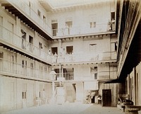 Tenement building, Aquila Street, 116, Cuba: a view of the courtyard, with inhabitants standing on balconies at each floor. Photograph, 1902.