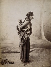 Tunisia: a Bedouin woman carrying her child on her back: studio portrait. Photograph, ca. 1890.