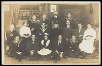 Sailors, some in drag, posing for a group portrait within a highly-detailed stage set. Photographic postcard, 191-.