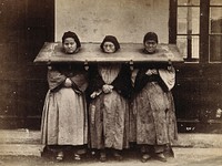 Shanghai: three Chinese women prisoners locked at the neck into one cangue (portable pillory). Photograph, 18--.