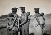 Africa: three women carrying babies on their backs in fabric slings. Photograph by Dudley Kidd, 1910/1930.