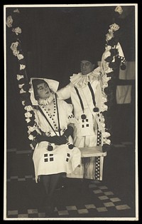Two British soldiers performing as clowns for "The Timbertown Follies", at a prisoner of war camp in Groningen. Photographic postcard, 191-.