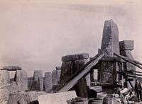 Stonehenge, England: the straightening of a leaning stone which is attached to a wooden frame and supported by beams and pulleys: raised upright. Photograph, 1901.