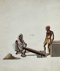 A man and a woman pounding and mixing grains or spices with a foot-operated mortar and pestle. Gouache painting by an Indian artist.