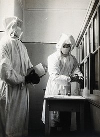 The inoculation of an isolated plague patient in China. Photograph.
