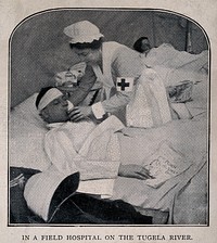 Boer War: a nurse lifts the head of a wounded man lying in a hospital ward. Halftone, c.1900.