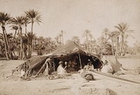 A tent with a Bedouin family in Northern Africa. Photograph.