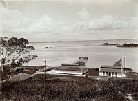 St. John's Island, Singapore: the Quarantine Station, showing the jetty, goods shed and distilling plant; small islands in the background. Photograph by A. R. Wellington, 1909.