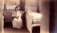 Bellevue Hospital, New York City: a female patient (criminal insane) in a cell with barred windows. Photograph.