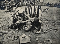 South Africa: a Zulu medicine man preparing to draw blood by cupping, first making an incision in the patient's shoulder. Process print after a photograph, ca. 1907.