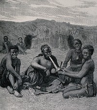 An African chief of the Barotsi tribe smoking his pipe which is held by a woman. Wood-engraving.