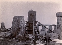 Stonehenge, England: the straightening of a leaning stone which is attached to a wooden frame and supported by beams and pulleys: raised upright. Photograph, 1901.