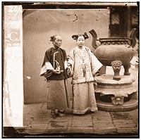 China: a Manchu lady with her maid standing beside a bronze burner, Beijing. Photograph by John Thomson, 1869.