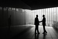 Two business men are hand shaking silhouette walking adult.