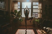 A woman poses for yoga in an apartment living room sports adult day.