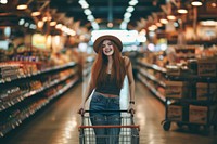 Woman is standing in aisle of market with shopping cart smiling adult architecture.