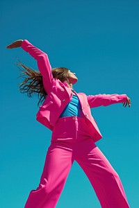 Woman in pink suit in front of blue dancing recreation triumphant hairstyle.