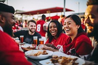 Fans tailgating outside a stadium laughing adult togetherness.