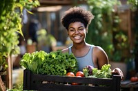 African-American women carrying a vegetable box smile adult outdoors.