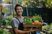 Young Chinese man carrying a vegetable box garden smile gardening.