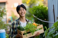 Young korean man carrying a vegetable box garden smile gardening.
