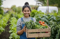 Young Latino woman carrying a vegetable box garden smile plant.