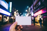 A white business card on the floor street night outdoors photo.
