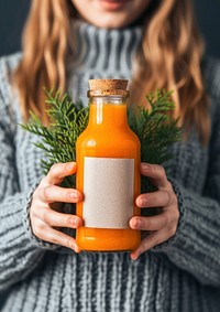 Woman holding a bottle of carrot juice drink refreshment midsection.