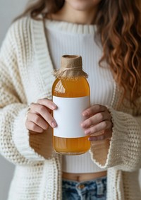 Woman holding a bottle of apple juice drink refreshment midsection.