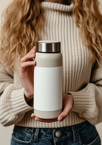 Woman holding a bottle of thermos jar refreshment container.