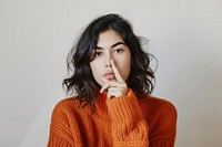 Woman make silent gesture portrait sweater photo.