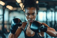 A black woman kickboxing in a bright gym to get a workout adult determination concentration.