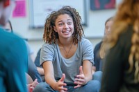 Girl seated with other teens adult togetherness conversation.
