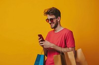 Smiling young man wear sunglasses using her smartphone adult shopping bag portability.