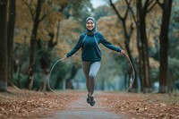 Young Asian woman in hijab doing jumping rope exercising adult determination.