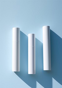 3 cosmetic tubes cylinder blue wall.