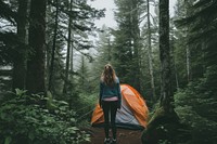 Woman coming out of tent camping in the woods recreation outdoors nature.