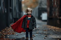Small child in a superhero costume and coat photography portrait walking.