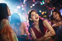 Asian group dancing at colorful house party at night laughing adult fun.