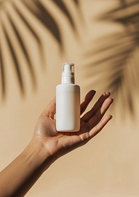 Hand holding skincare bottle cosmetics container perfume.