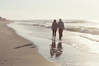 Older couple walking together beach standing outdoors.