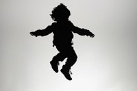A kid jumping silhouette backlighting monochrome.