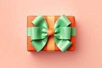 Pink gift with bright orange bow ribbon green green background.