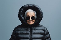 Old woman wearing an black oversized puffer jacket hood portrait photo.