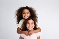 Mixed race girl piggybacking her sister portrait child smile.