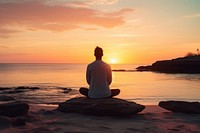 Middle age man doing yoga outdoors sitting sunset.