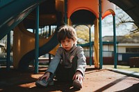 A kid with autism playing in the playground outdoors looking child.