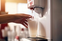 Close up hand holding paper soda cup to pour a blank white drink machine milk refrigerator coffeemaker.
